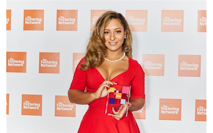 Louise in a red dress holding an award.